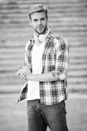 Man millennial generation listen audio. Music lover lifestyle. Millennial man in music headphones outdoor. Modern lifestyle. Student life. Student man has music in headphones. Casual coolの写真素材