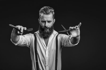 Man barber making a haircut in a barbershop. Great time at barbershop. Haircut by hairdresser at barbershop. Barber man. Man barber with razor blade do haircut. Glamorous hairstylingの写真素材