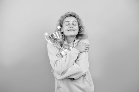 Sport success and victory. Woman holding champion cup. Woman winner in sport. Successful sport. Being a true champion. Celebrating success. Woman champion isolated on blue. Championship winnerの写真素材