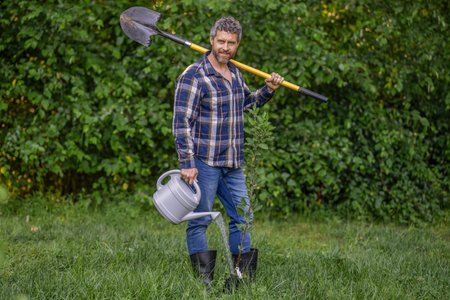 Planting and growing plant. Spring farming, springtime. Planting tree. Gardening and farming. Hispanic farmer with shovel. Gardener planting vegetable in spring garden. Farmer in spring farmの写真素材