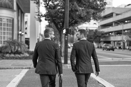 Business men crossing the street. Walk of two business men. Colleague in New York. Success. Businessmen in suit walk outdoor. Walk to success. Two businessmen walk in the cityの写真素材
