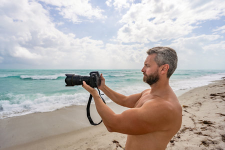 Traveling and photography. Photographer take photo with camera. Traveler camera man on summer beach. Travel photography. Coastal photography. Photo camera at beach. Summer beach vacationの写真素材