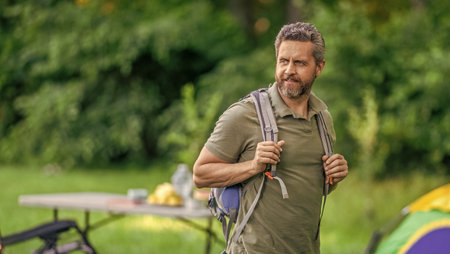 Man having camp picnic in forest with tent. Man hiking on summer day. Summer camp activity. Summer...