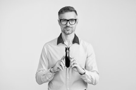 Mature man presenting electric razor. Haircare and shaving. Personal care and daily routine. Barbershop. Hair clipper for man. Man with hair trimmer. Man holding electric shaver. Mens beautyの写真素材