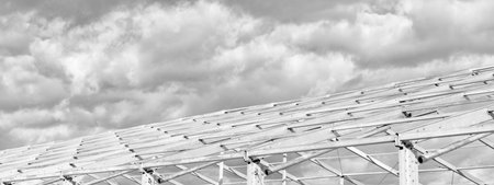 Metal construction. Structural design engineering. Structure engineering at building site. Framework construction architecture. Architectural design. Installation of metal structure at cloudy skyの写真素材