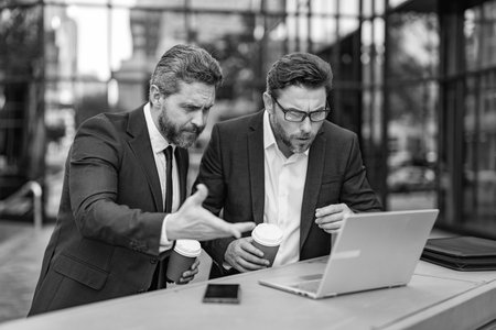 Business online. Men working on laptop. Businessmen working online. Businessmen in suit with laptop. Online working. Businessmen checking email. Business men freelancing outdoor. Dealing with problemの写真素材