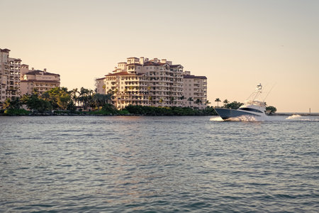 Fisher island residential building and luxury yacht boat. Motorboat passing Fisher island, Miami. Miami architecture, Florida. Luxury yacht boat at Fisher island. Summer vacationの写真素材
