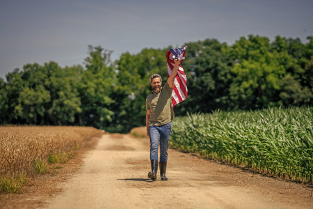 Man in field. Man with American flag in crop field. Independence day of America. 4th of July....