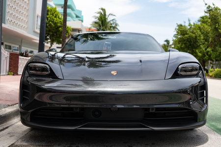 Miami, Florida, USA - July 12, 2025: Porsche Taycan 2020 electric car. Luxury electric car Porsche Taycan. Car Porsche Taycan parked outdoor. Black electric car, corner viewのeditorial素材