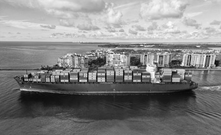 Miami, Florida, USA - June 07, 2024: Freight container loaded on cargo vessel in Miami. Aerial view...