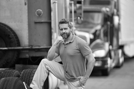 Handsome man driver in front of truck. Trucking owner. Truck driver. Man trucker driver near lorry...