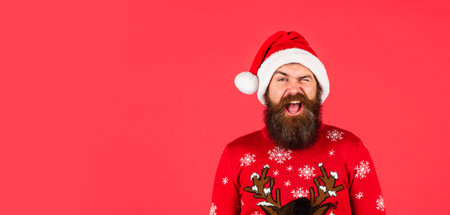 handsome man at Christmas. brutal bearded male red background. party man in Christmas sweater. happy...