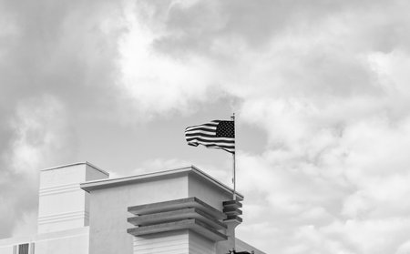 American flag on building. Flag of the USA. National waving flag of united states on blue sky. Independence day. Patriotic symbol. American Flag for Memorial Day or 4th of Julyの写真素材