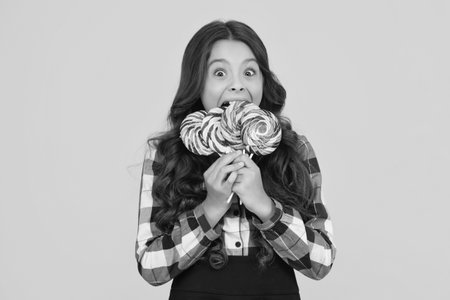 Surprised teen girl holding lollipop sweet nd yummy candy isolated on white, lollypopの写真素材