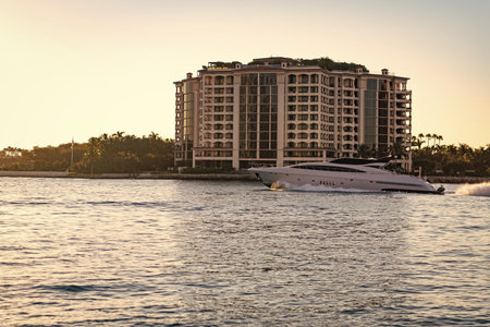 Luxury yacht boat at Fisher island. Summer vacation. Fisher island residential building and luxury yacht boat. Motorboat passing Fisher island, Miami. Miami architecture, Florida. Touristic landmarkの写真素材