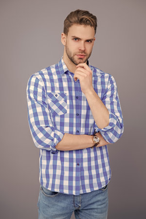 Man isolated on grey. Millennial man wearing checkered shirt. Casual style of millennial man. Portrait of man in casual style shirt. Stylish portrait of unshaven guy. Comfortable clothingの写真素材
