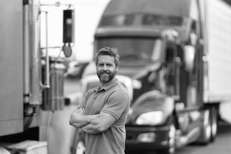 Handsome man driver in front of truck. Trucking owner. Truck driver. Man trucker driver near lorry...