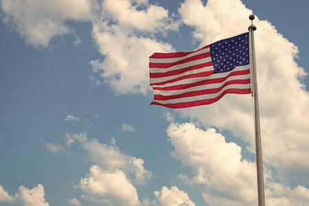 Independence day. Patriotic symbol. American Flag for Memorial Day or 4th of July. American flag waving, labor day. Flag of the USA. National waving flag of united states on blue skyの写真素材