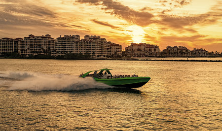 Luxury motor boat yacht. Yacht go to marina. Boating and yachting. Luxury lifestyle. Yacht at luxury residential building. Vacation on summer. Romantic sunsetの写真素材