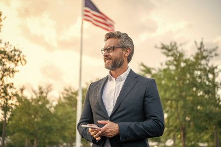 Business man chatting on phone outdoor. Businessman using phone. Man phone chat in suit. Mature Hispanic business man with phone. Business communication. Messaging and textingの写真素材