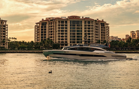 Summer vacation. Fisher island residential building and luxury yacht boat. Boat passing Fisher...