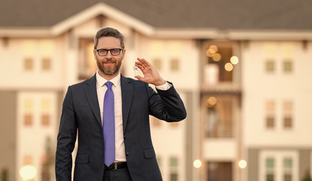 Property insurance services. Ownership. American settlement agent. Real estate agent sell property. Realtor key in suburb neighborhood. Man purchasing house for investment purpose, bannerの写真素材