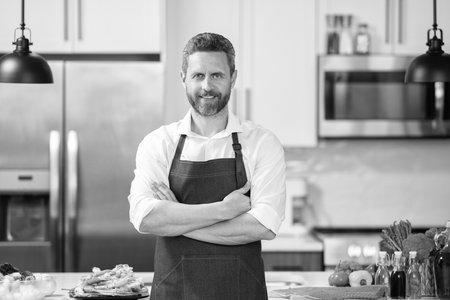 Man cook healthy food in apron. Cooking at home. Mature professional man cook healthy food. Home...