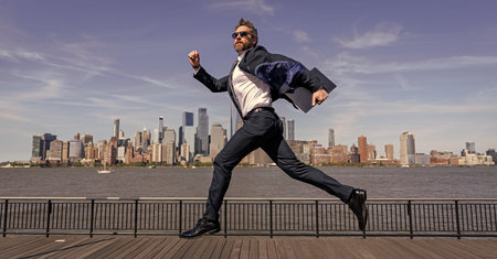 Business man in Manhattan. Business success in big city. Businessman running to success. Business success. Successful businessman hurrying on New York city skyline. Fast businessの写真素材
