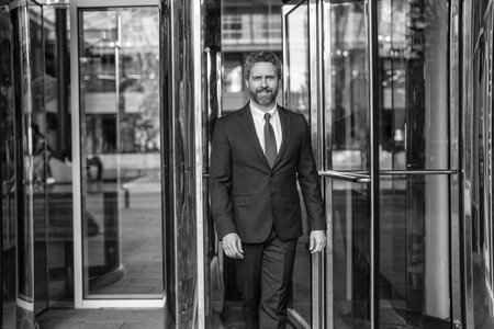 Man in suit walk to office. Hispanic businessman at office building. Business success man outdoor. Man walking in city street. Businessman in suit. Business success of businessman. Meeting partnerの写真素材