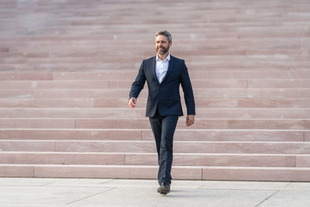 Ambitious businessman in suit. Business boss man walk on stairs. Successful business and leadership. Business entrepreneur success. Businessman walking on stairs. Successful businessman leaderの写真素材