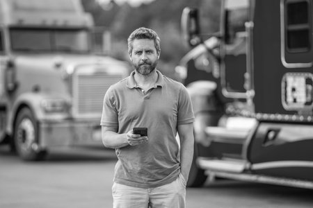 Truck driver. Trucking owner planning route. Hispanic man control truck. Man owner truck driver. Transportation logistic. Delivery app. Logistics software. Man driver use phone at lorry truckの写真素材