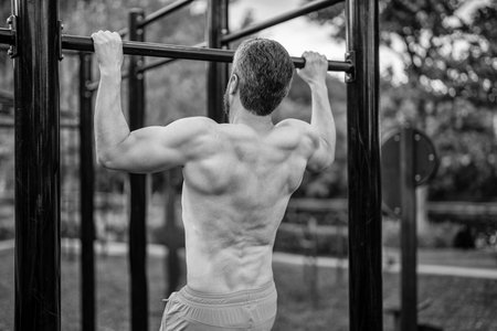 Sport pullup workout. Sport training. Man sportsman do pulling exercise. Man muscular back athlete...