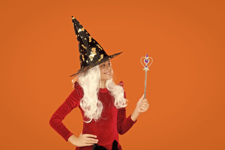 Halloween costume party. All Hallows witch girl. Girl in witch costume hold magic wand. Happy...