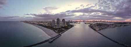 Aerial view of night South Beach coastline. Miami skyline with tropical blue waters panorama....