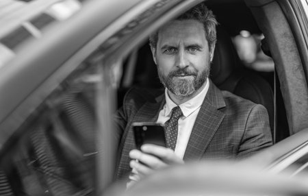 Man in suit using phone in car. Hispanic businessman with phone. Successful business. Businessman...