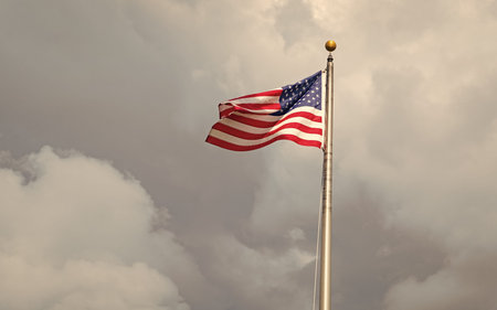 National waving flag of united states on blue sky. Independence day. Patriotic symbol. American Flag...