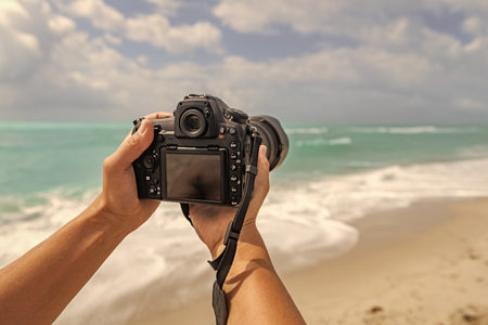 Summer beach vacation. Traveling and photography. Photographer making photo with camera. Traveler...