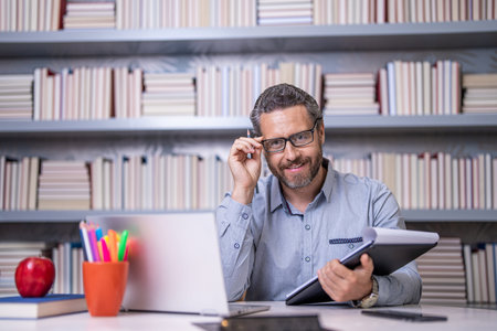 Teacher in classroom. school tutor with book in classroom. Man in class. strong educational...
