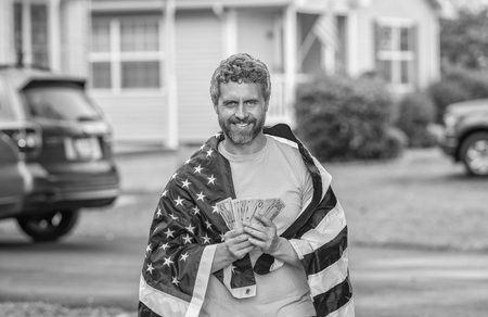 Paying tax in America. Value added tax. Taxation system. Patriotic man. Man with American flag and dollar money. Inflation concept. American tax policy. Hispanic man and USA flag. Salary in USAの写真素材
