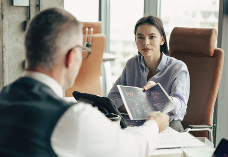 Millennial business colleague with diagram in office. Woman at conference. Businesspeople discuss...