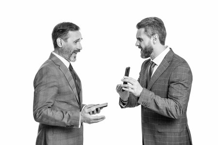 businessmen having negotiation on phone isolated on white. business texting in online blog. online business blogging. business men in suit use phone communication. communication onlineの写真素材