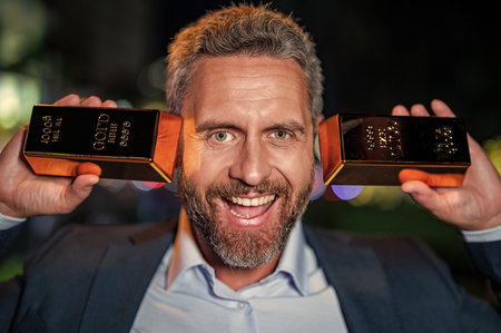 Investment in precious metal. Golden bullion bar. Rich businessman hold gold bullion. Financial...