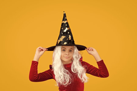 Happy Halloween. Girl witch in Halloween costume isolated on yellow. Trick or treat. Celebrate All...