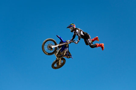 Miami, Florida, USA - May 25, 2025: Motocross rider performing stunt. Motocross rider performing...