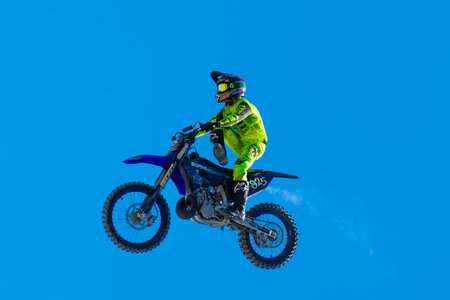 Miami, Florida, USA - May 25, 2025: Freestyle motocross FMX. Professional rider at FMX Freestyle Motocross competition. Motorbike stunt performed by rider in action against blue sky