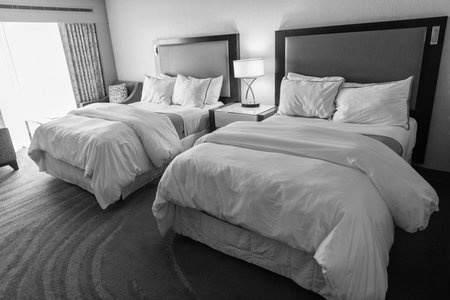 Hotel room with cozy bed in bedroom. Home design. Furniture for bedroom. Interior design in apartment. Comfortable bed in hotel bedroom. Bedding and accommodation