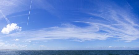 Dynamic clouds on a blue sky over North Sea panoramaの写真素材