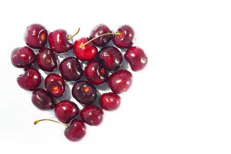 Cherry with water drop in heart shape on isolated background. Copy space.の写真素材