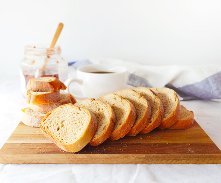 Bread on a chopping board with strawberry jam and coffe. Selective focus. Still life. Copy space.