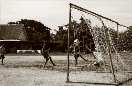 Boys were playing football in the grass field. While striker kicked ball and it was passing goalkeeper into the net. The image was taken right now.のeditorial素材